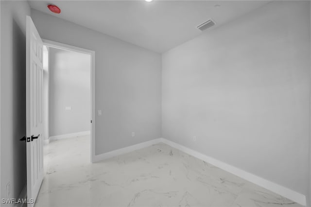 spare room featuring visible vents, marble finish floor, and baseboards