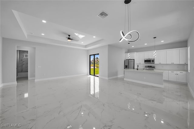 unfurnished living room featuring a raised ceiling, recessed lighting, baseboards, and visible vents