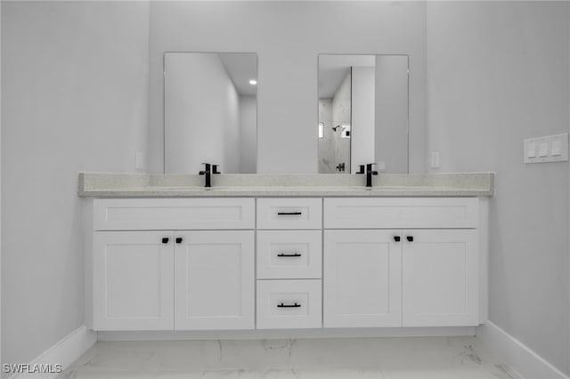 full bath with baseboards, marble finish floor, and a sink