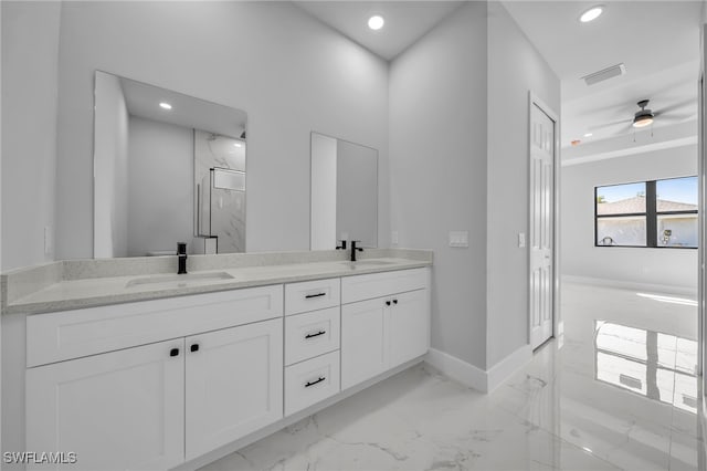 bathroom with double vanity, marble finish floor, a marble finish shower, and a sink