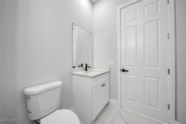 bathroom featuring baseboards, toilet, marble finish floor, and vanity