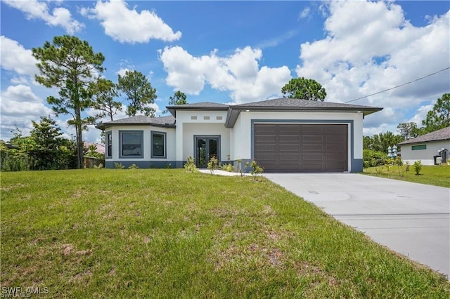 prairie-style home featuring stucco siding, driveway, french doors, a front yard, and an attached garage