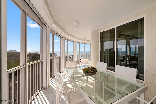 sunroom / solarium featuring a water view