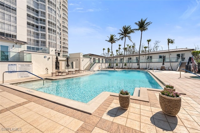 pool with a patio area and fence