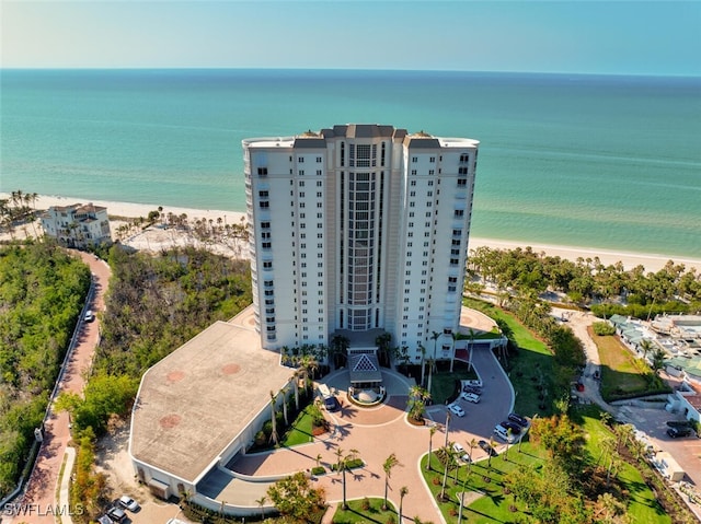 drone / aerial view featuring a water view and a view of the beach