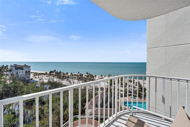 balcony featuring a water view and a beach view