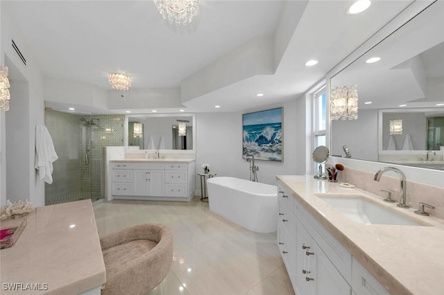 full bathroom with recessed lighting, two vanities, a stall shower, a sink, and a freestanding tub