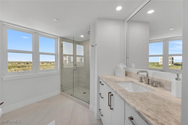 bathroom featuring a shower stall, plenty of natural light, baseboards, and vanity