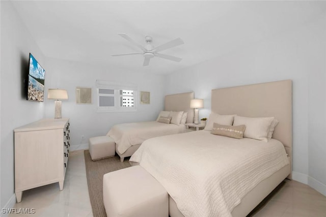 bedroom featuring ceiling fan, light tile patterned floors, and baseboards