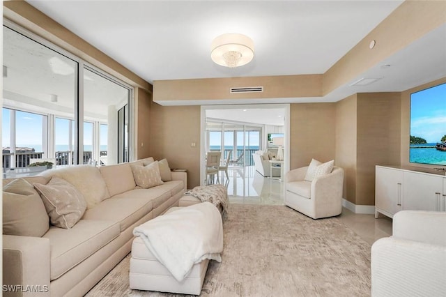 living room featuring a healthy amount of sunlight, visible vents, and baseboards