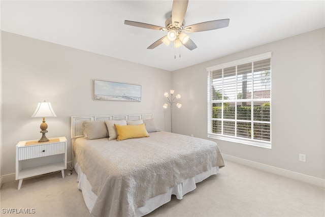 bedroom with baseboards, a ceiling fan, and light colored carpet