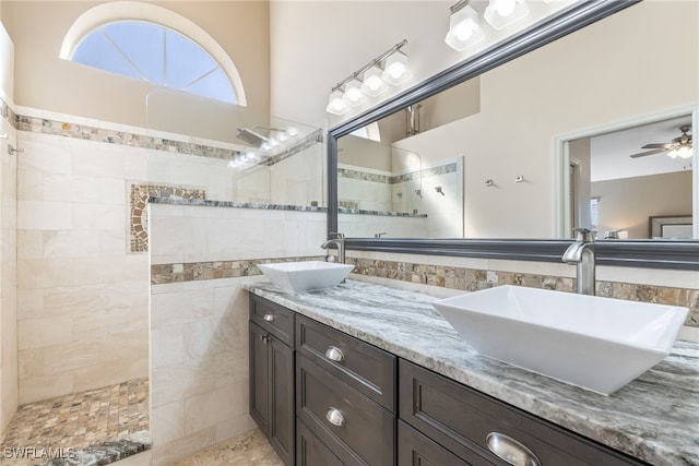 full bathroom with ceiling fan, double vanity, walk in shower, and a sink