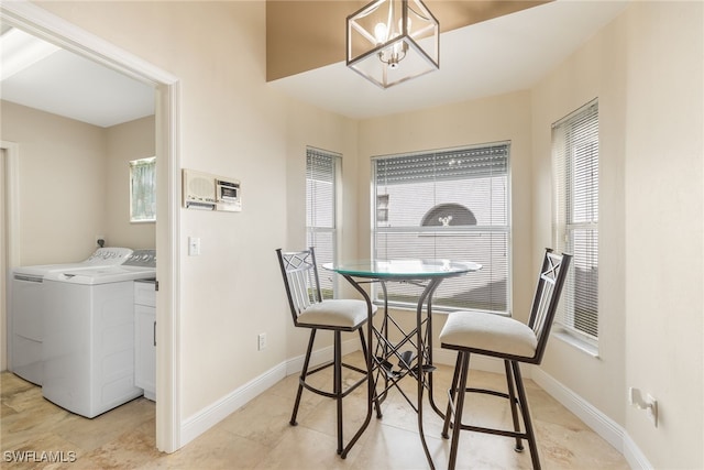 dining area with an inviting chandelier, baseboards, a wealth of natural light, and washer and dryer