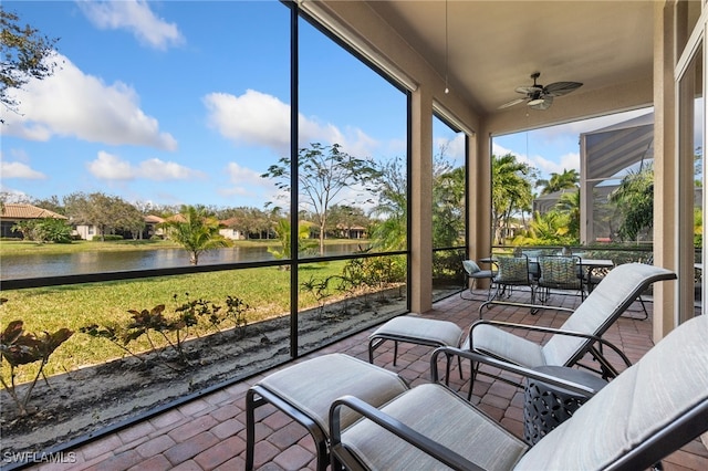 sunroom with a water view and ceiling fan