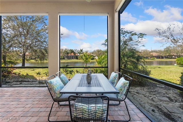 sunroom / solarium featuring a water view and plenty of natural light