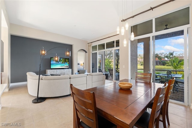 dining area with light tile patterned floors and arched walkways