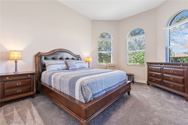 bedroom featuring dark colored carpet and baseboards