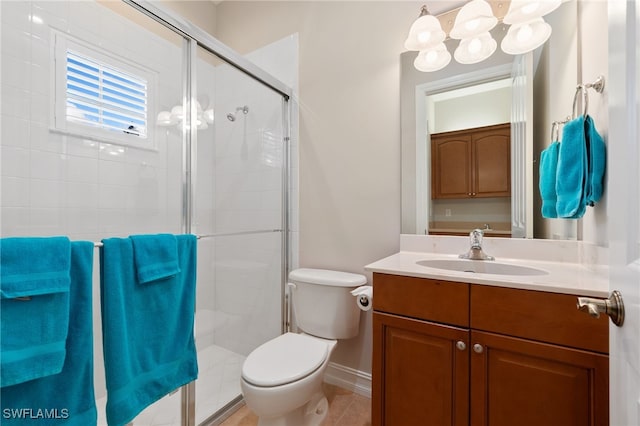 bathroom featuring baseboards, a shower stall, toilet, and vanity