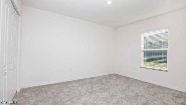 unfurnished room with carpet floors and baseboards