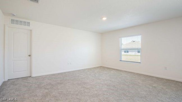 carpeted spare room with baseboards and visible vents