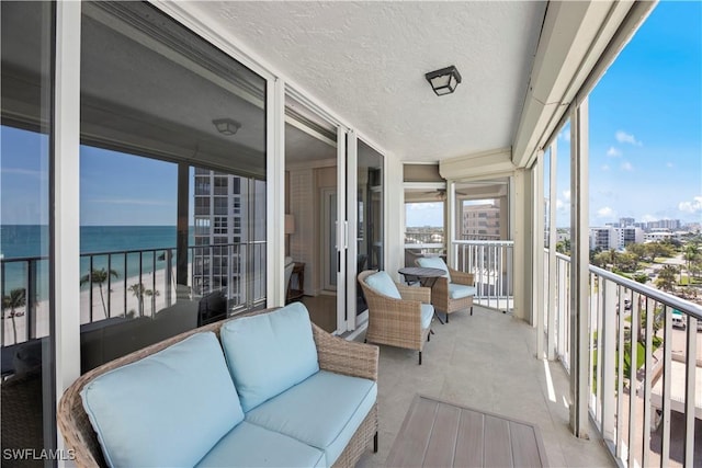 balcony featuring a water view, a view of city, and an outdoor living space