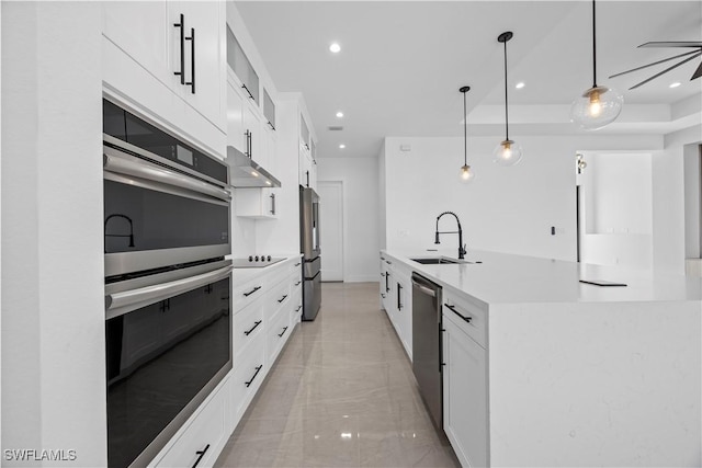 611 NW 25th Ter, Cape Coral, FL 33993 - kitchen with appliances with stainless steel finishes, under cabinet range hood, white cabinetry, light countertops, and recessed lighting