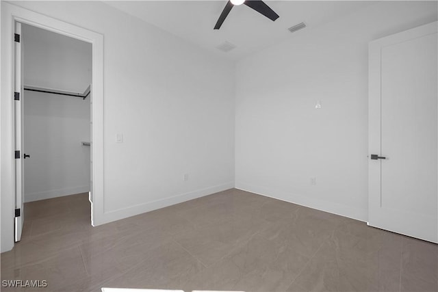 611 NW 25th Ter, Cape Coral, FL 33993 - unfurnished bedroom with a walk in closet, a ceiling fan, and a closet