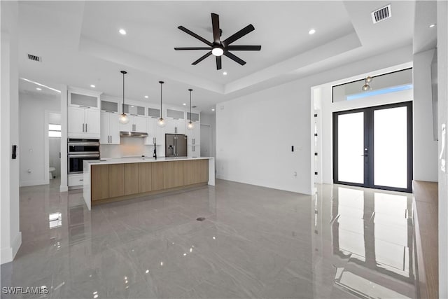 611 NW 25th Ter, Cape Coral, FL 33993 - kitchen featuring stainless steel appliances, a tray ceiling, recessed lighting, open floor plan, and light marble finish floors