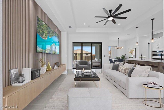 611 NW 25th Ter, Cape Coral, FL 33993 - living area featuring a raised ceiling, a ceiling fan, wooden walls, a chandelier, and recessed lighting