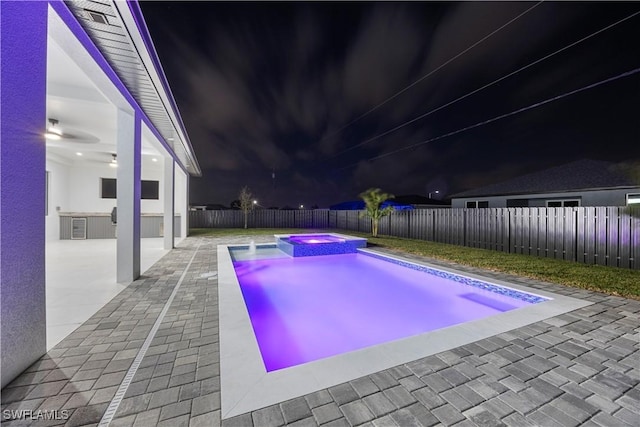 611 NW 25th Ter, Cape Coral, FL 33993 - pool at twilight featuring a fenced backyard, a patio area, and a pool with connected hot tub