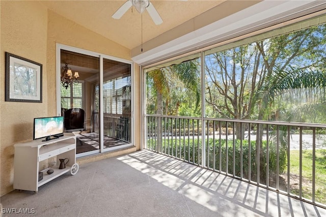 sunroom with vaulted ceiling, ceiling fan with notable chandelier, and a wealth of natural light