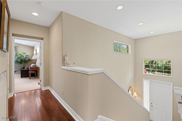 hallway featuring recessed lighting, dark wood finished floors, an upstairs landing, and baseboards