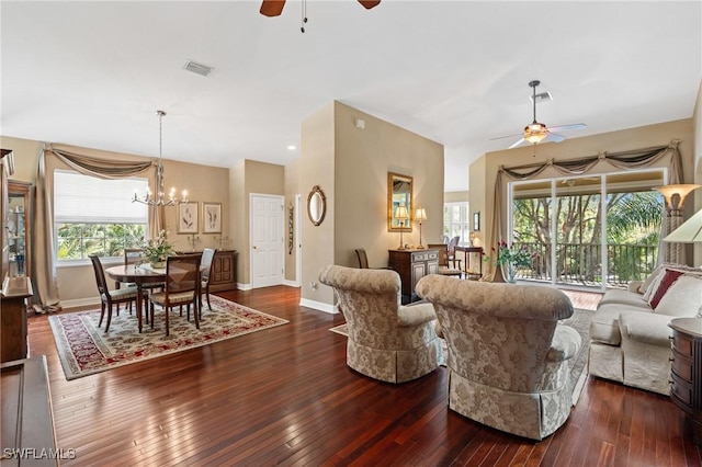 living area featuring wood-type flooring, visible vents, baseboards, and ceiling fan with notable chandelier