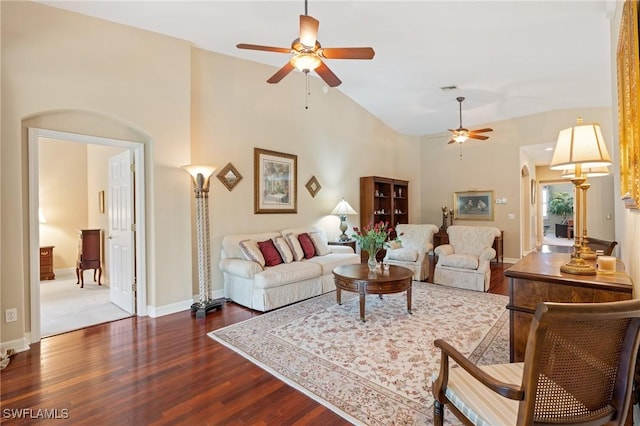 living room with ceiling fan, a high ceiling, wood finished floors, visible vents, and baseboards