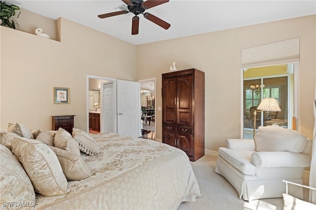 bedroom featuring baseboards, light colored carpet, ensuite bath, and ceiling fan with notable chandelier