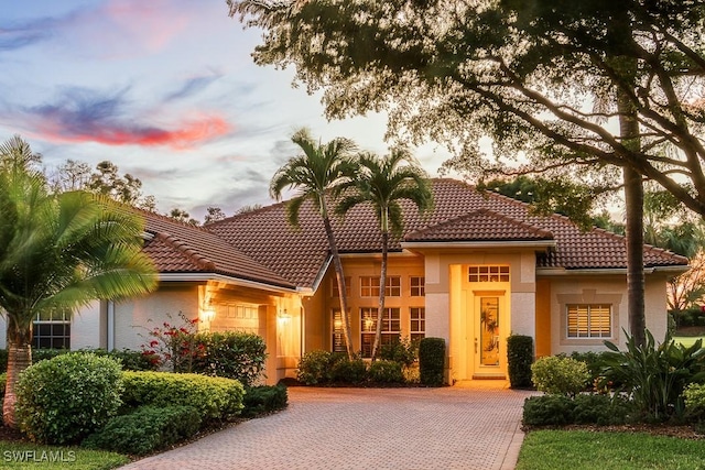 mediterranean / spanish house with a tile roof and stucco siding