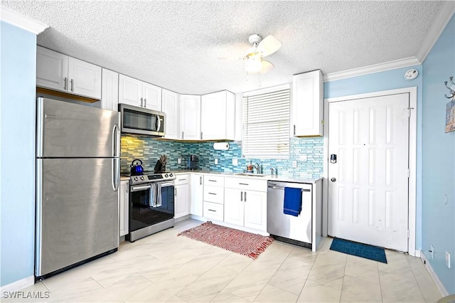 kitchen featuring stainless steel appliances, light countertops, white cabinetry, and backsplash