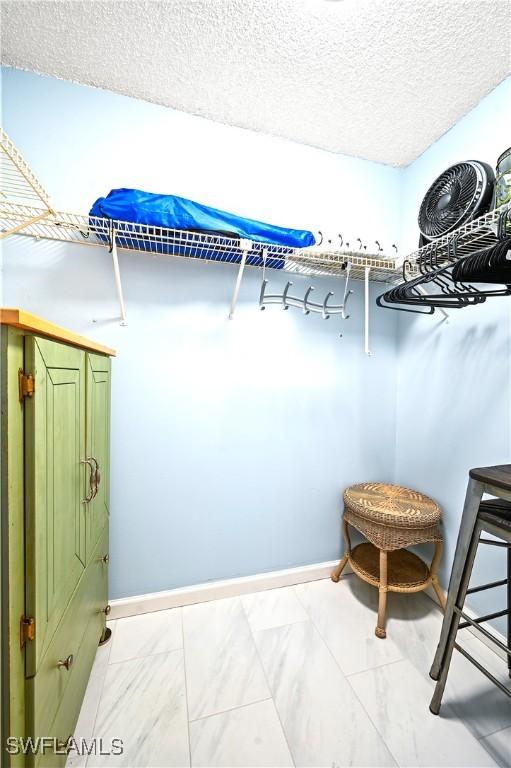 walk in closet with marble finish floor