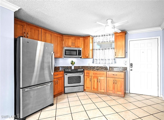 kitchen with brown cabinets, crown molding, stainless steel appliances, a sink, and ceiling fan