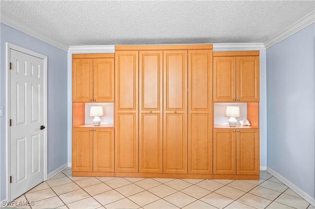 interior space featuring light tile patterned flooring, crown molding, a textured ceiling, and baseboards