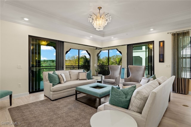 living area featuring a chandelier, recessed lighting, baseboards, light wood finished floors, and crown molding