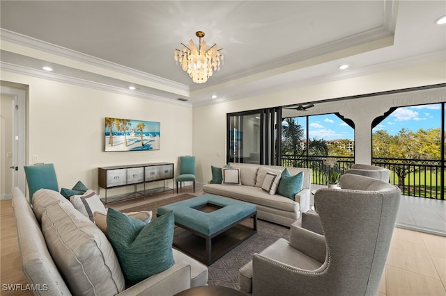 living area with ornamental molding, recessed lighting, a raised ceiling, and a notable chandelier