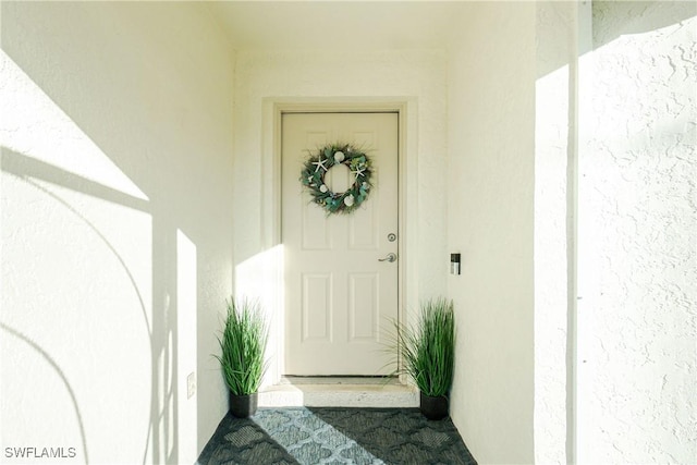 view of exterior entry featuring stucco siding