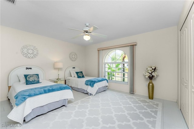 bedroom with a ceiling fan, a closet, and baseboards