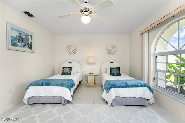 bedroom with a ceiling fan, visible vents, and tile patterned floors