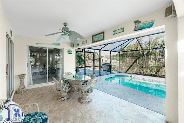 pool featuring ceiling fan, glass enclosure, outdoor dining area, and a patio area