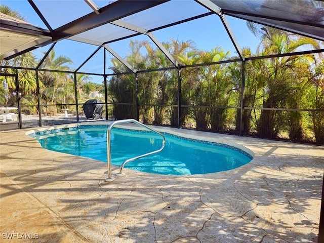 outdoor pool with glass enclosure and a patio area