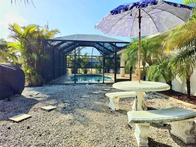 view of yard with a patio, glass enclosure, and an outdoor pool