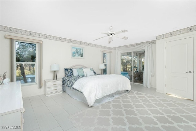 bedroom with access to exterior, multiple windows, baseboards, and a ceiling fan