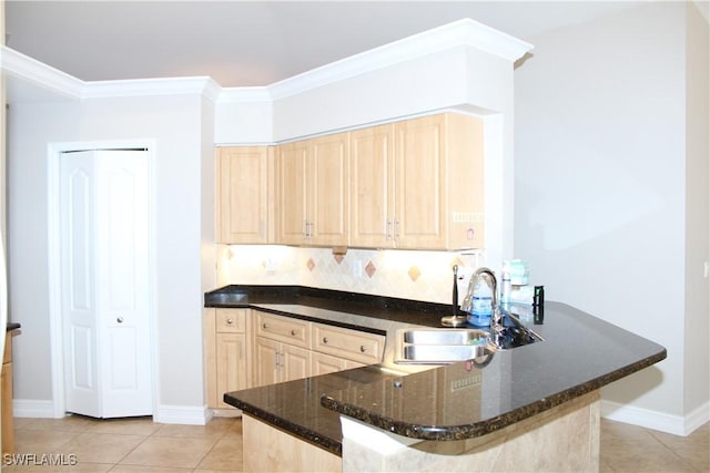 kitchen with light brown cabinets, light tile patterned floors, a sink, and crown molding